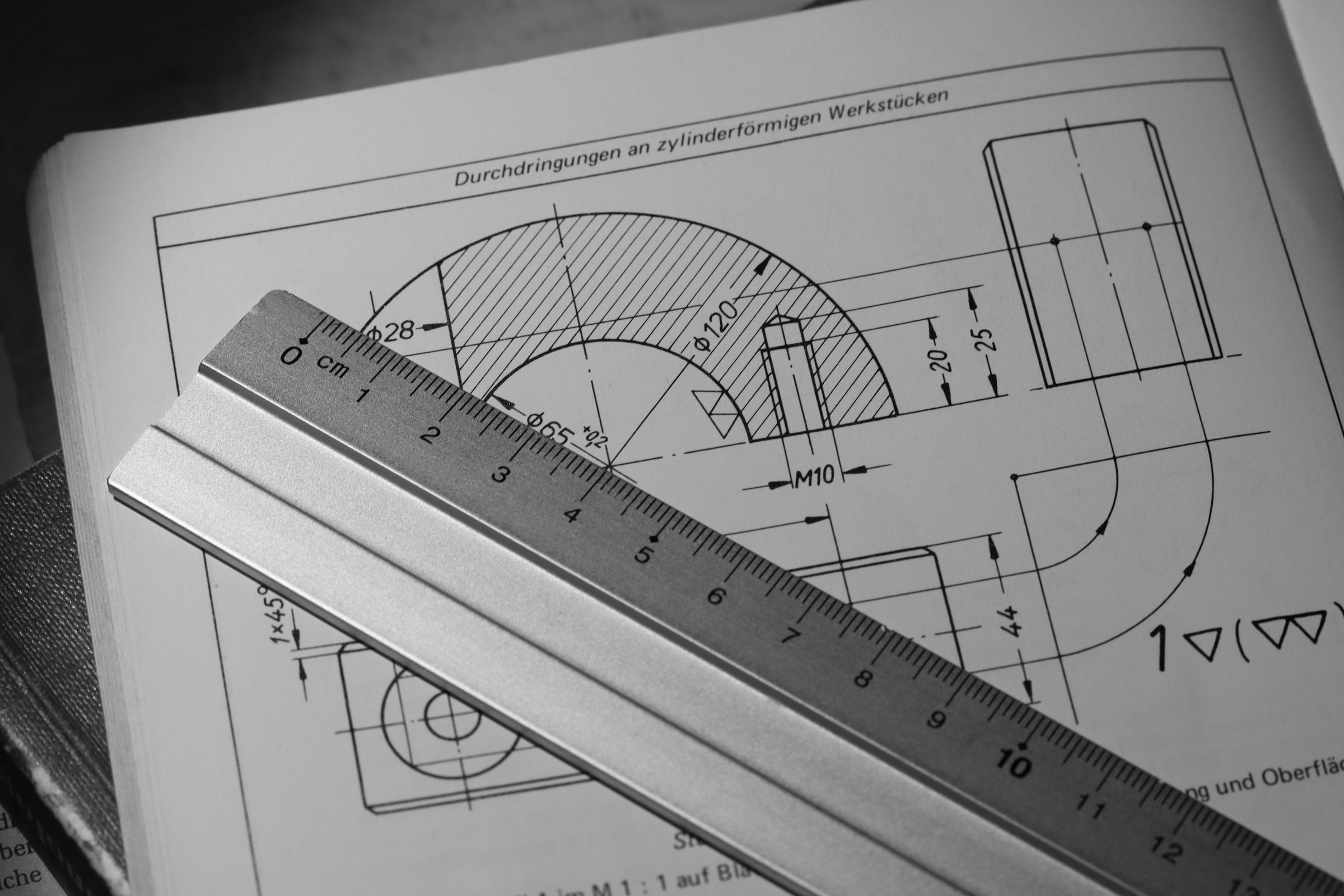 Eine bemasste technische Zeichnung mit Stahllineal, mit Toleranzen und Rauheitszeichen